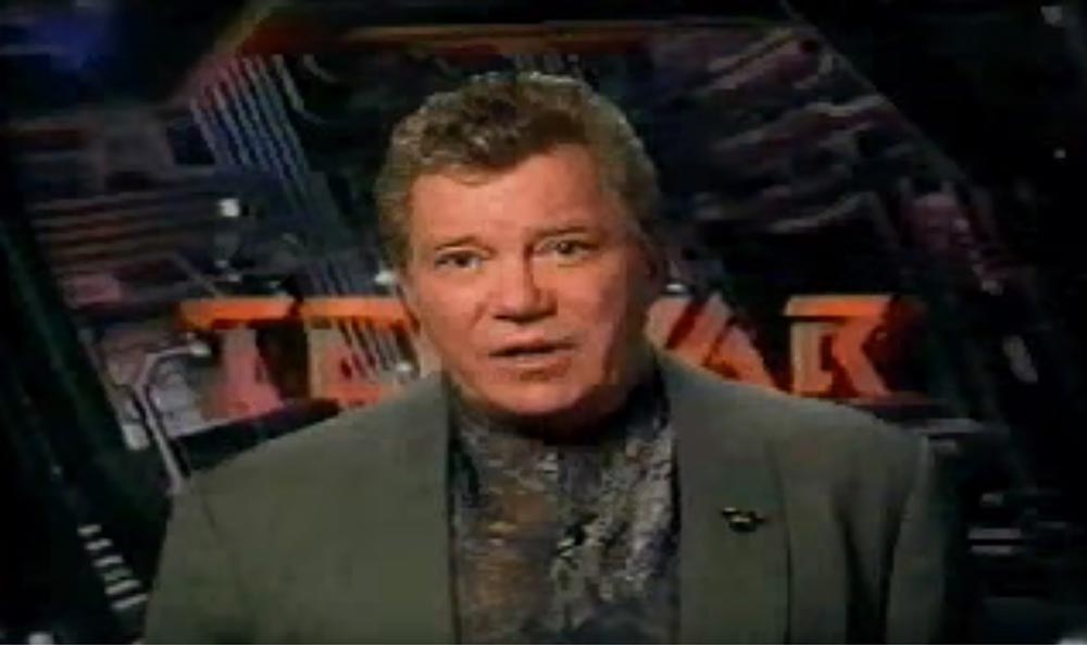 William Shatner in a green suit in front of the TekWar logo